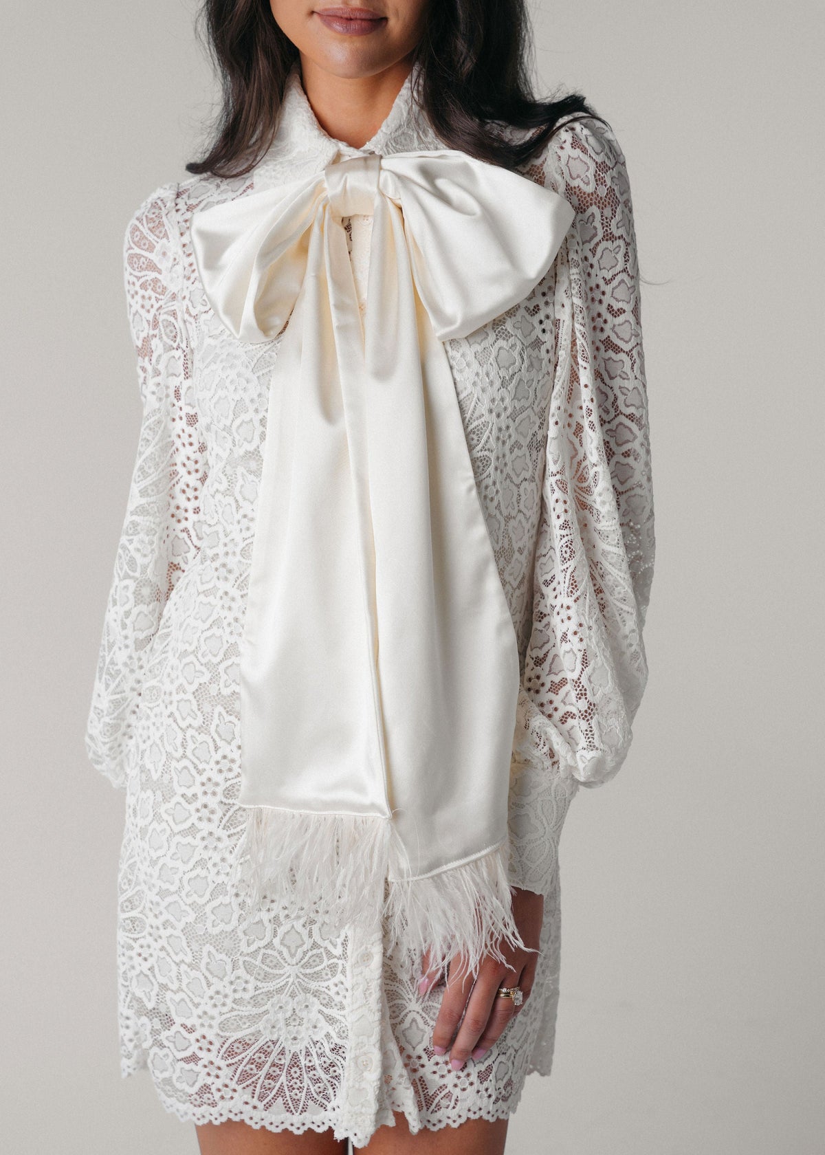 Samantha Wood Fashion Designer Bridal Era Collection Charlotte White Lace Shirt Dress on Model Front With Satin Ostrich Feather Bow Detail